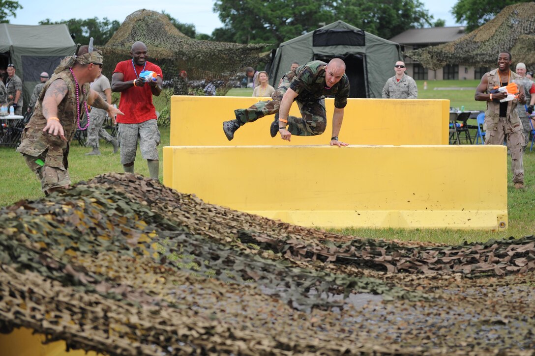 Air Force Capt. Harlan Glinski jumps over barriers during the 81st Mission Support Group Combat Dining-In at Keesler Air Force Base, Miss., June 10, 2016. The event promotes camaraderie and esprit de corps throughout the ranks. Glinski is operations officer for the 81st Security Forces Squadron. Air Force photo by Kemberly Groue