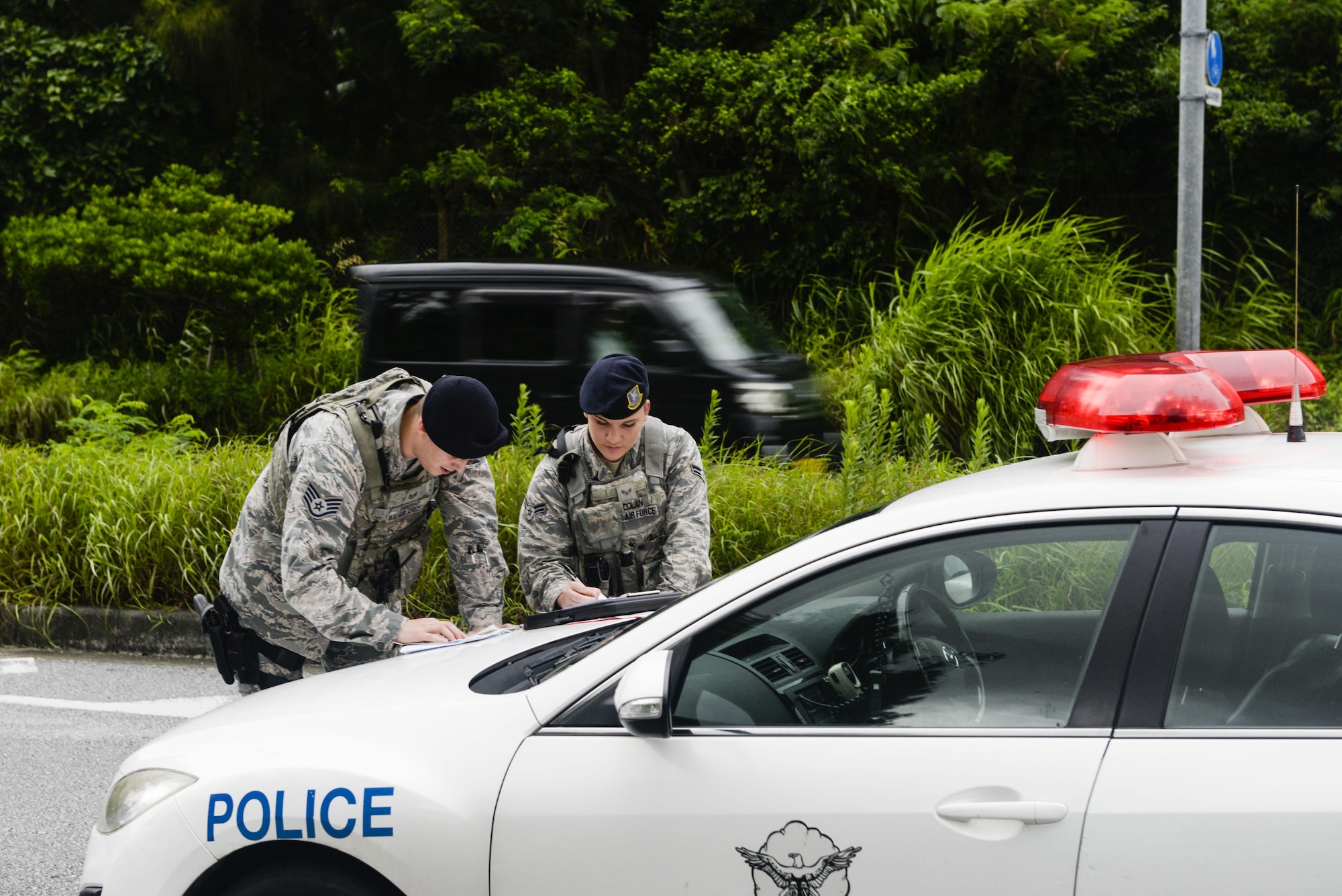 Staff Sgt. Troy Turnbo and Airman 1st Class Rachel Dolan, 18th Security Forces Squadron patrolmen, write an accident report for a minor vehicle accident near Kadena Air Base, Japan, June 13, 2016. To be a "Defender," it takes a high volume of training and the knowledge in weaponry, laws, directives and programs, policies, and procedures governing security forces activities, as well as a motivated individual ready for the task at hand. (U.S. Air Force photo by Senior Airman Stephen G. Eigel)