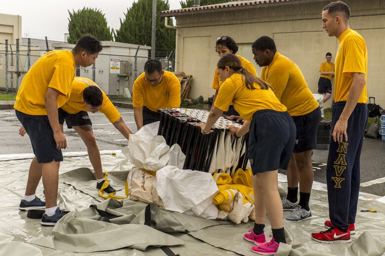 U.S. Navy Sailors from the Robert M. Casey Medical and Dental Clinic set up a three-line articulating frame shelter during first-receiver operations training at Marine Corps Air Station Iwakuni, Japan, June 9, 2016. Provided by the Decontamination, Education and Consulting on Nuclear, Biological and Chemical Limited Liability Company, the course educates first receivers in conducting decontamination, field treatment and saving victims from chemical, biological, radiological and nuclear threats. (U.S. Marine Corps photo by Lance Cpl. Aaron Henson/Released)