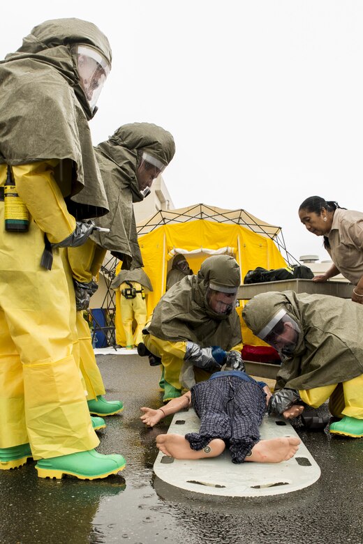 U.S. Navy Sailors from the Robert M. Casey Medical and Dental Clinic assess a simulated victim during first-receiver operations training at Marine Corps Air Station Iwakuni, Japan, June 9, 2016. Provided by the Decontamination, Education and Consulting on Nuclear, Biological and Chemical Limited Liability Company, the course educates first receivers in conducting decontamination, field treatment and saving victims from chemical, biological, radiological and nuclear threats. The training included testing the sailors’ abilities when dealing with CBRN patients by donning disposable-toxicological-agent-protective suits to assemble a three-line articulating frame shelter system that enables victims to be processed as quickly as possible. (U.S. Marine Corps photo by Lance Cpl. Aaron Henson/Released)