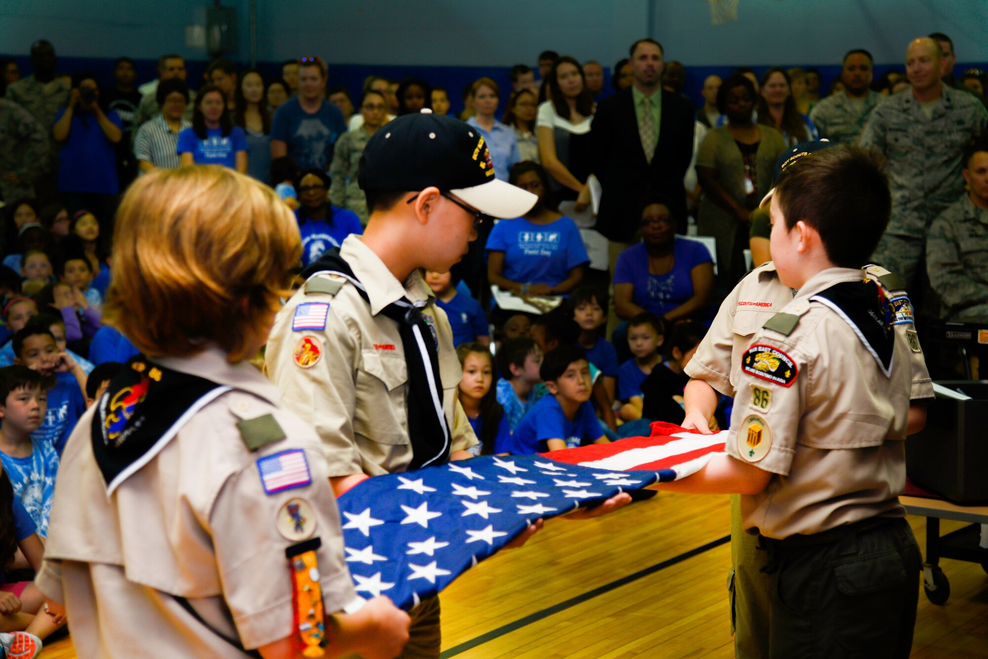 Members of the Boy Scouts of America Troop 86 perform a flag folding ceremony during the Osan Elementary School closing ceremony June 15, 2016, at Osan Air Base, Republic of Korea. The folded flag represents a memory of their school and was placed in a time capsule to be opened in the future. (U.S. Air Force photo by Senior Airman Dillian Bamman/Released)