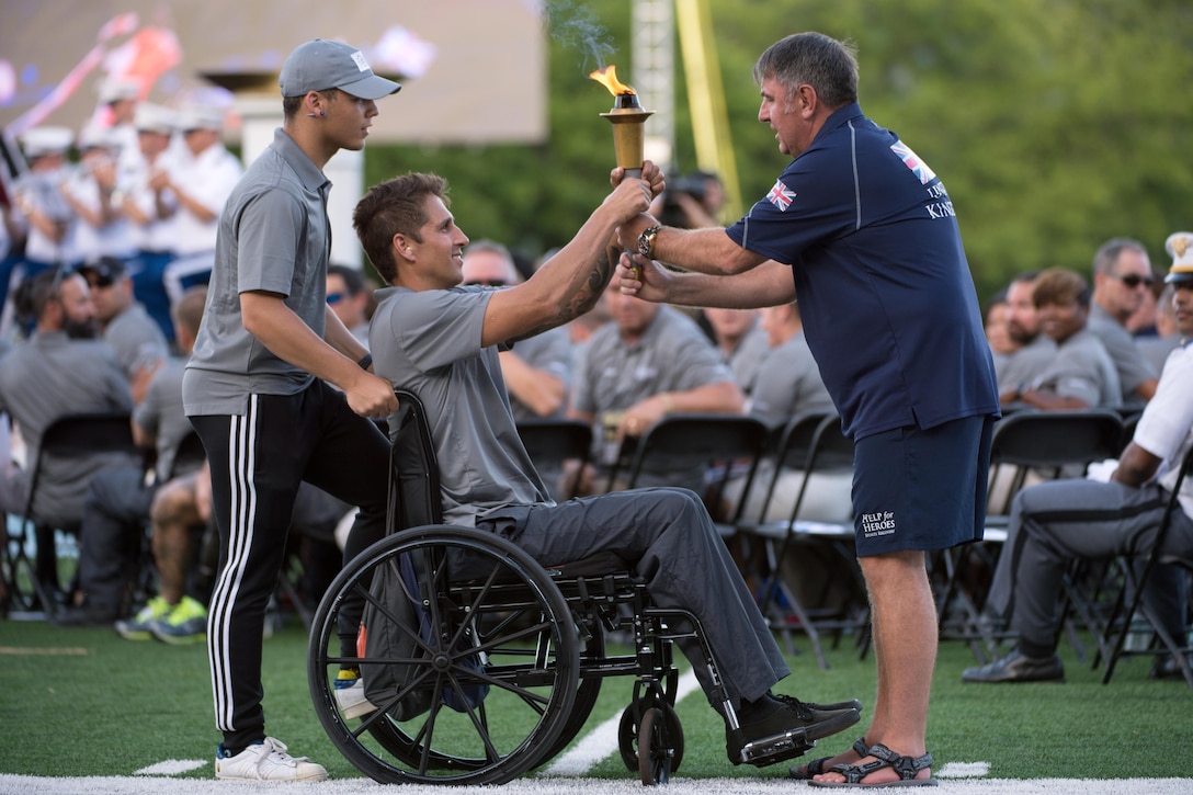 Navy Lt. Ramesh Haytasingh, center, assigned to the Special Operations Command team, accepts the 2016 Department of Defense Warrior Games torch from Great Britain’s army Maj. Brian Seggie during opening ceremonies at the U.S. Military Academy in West Point, N.Y. June 15, 2016. DoD photo by EJ Hersom