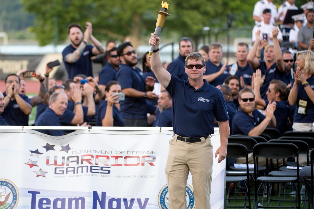 Navy Chief Petty Officer Ron Condrey holds up the 2016 Warrior Games torch for the Navy team during opening ceremonies at the U.S. Military Academy in West Point, N.Y., June 15, 2016. DoD photo by EJ Hersom