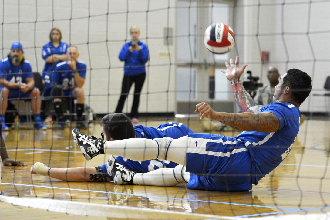 Air Force Tech. Sgt. Christopher Ferrell reaches for the ball during a sitting volleyball competition against the U.S. Special Operations Command team during the 2016 Department of Defense Warrior Games at the U.S. Military Academy in West Point, N.Y., June 15, 2016. Air Force photo by Staff Sgt. Carlin Leslie