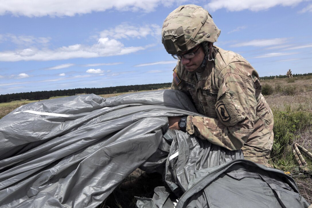 A paratrooper recovers a chute after participating in an airborne operation during Anakonda 2016 at Piaskowi drop zone in Drawsko Pomorskie, Poland, June 6, 2016. Army photo by Pfc. Antonio Lewis 