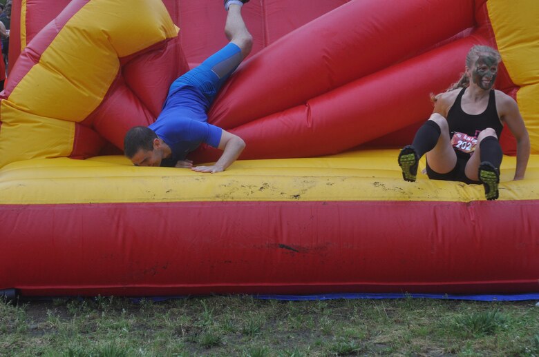 Participants in Run Amuck tumble over the tube wall obstacle.