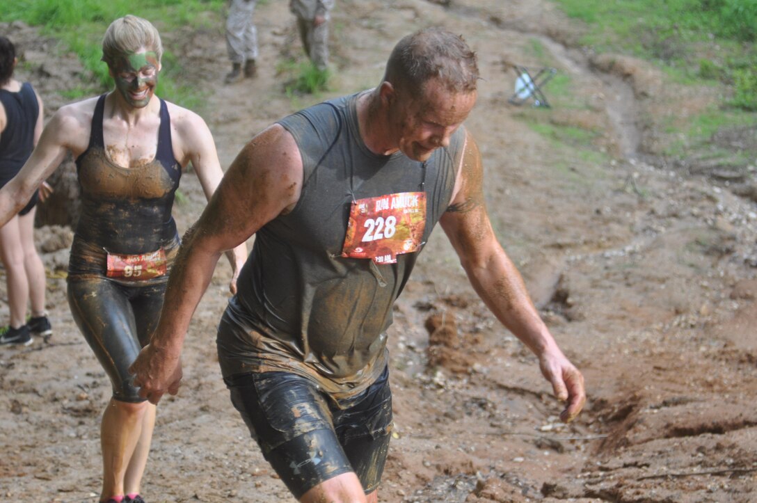 Stephen Lynch of Dumfries, Virginia and Christine Hanke of Arlington, Virginia are all smiles coming out of the steep mud pit at the end of the course.