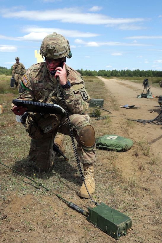 A U.S. paratrooper checks communications during Anakonda 2016 at Piaskowi drop zone in Drawsko Pomorskie, Poland, June 6, 2016. Army photo by Pfc. Antonio Lewis