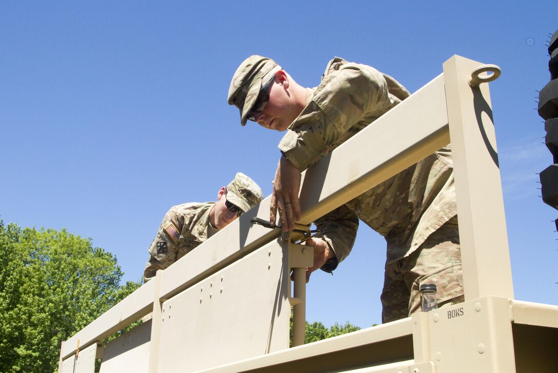 JOINT BASE MCGUIRE-DIX-LAKEHURST, N.J. - Horizontal construction engineers Spc. Kory Klinger (left) of Halifax, Pa., and Sgt. Drew Ulmer of New Columbia, Pa., make sure everything is secure on the back of a light equipment transport vehicle before it is driven. The Soldiers are members of the 333rd Engineer Company, based in Reading, Pa., are participating in training exercise Castle Installation Related Construction 2016.  (U.S. Army photo by Sgt. Anshu Pandeya, 372nd Mobile Public Affairs Detachment)