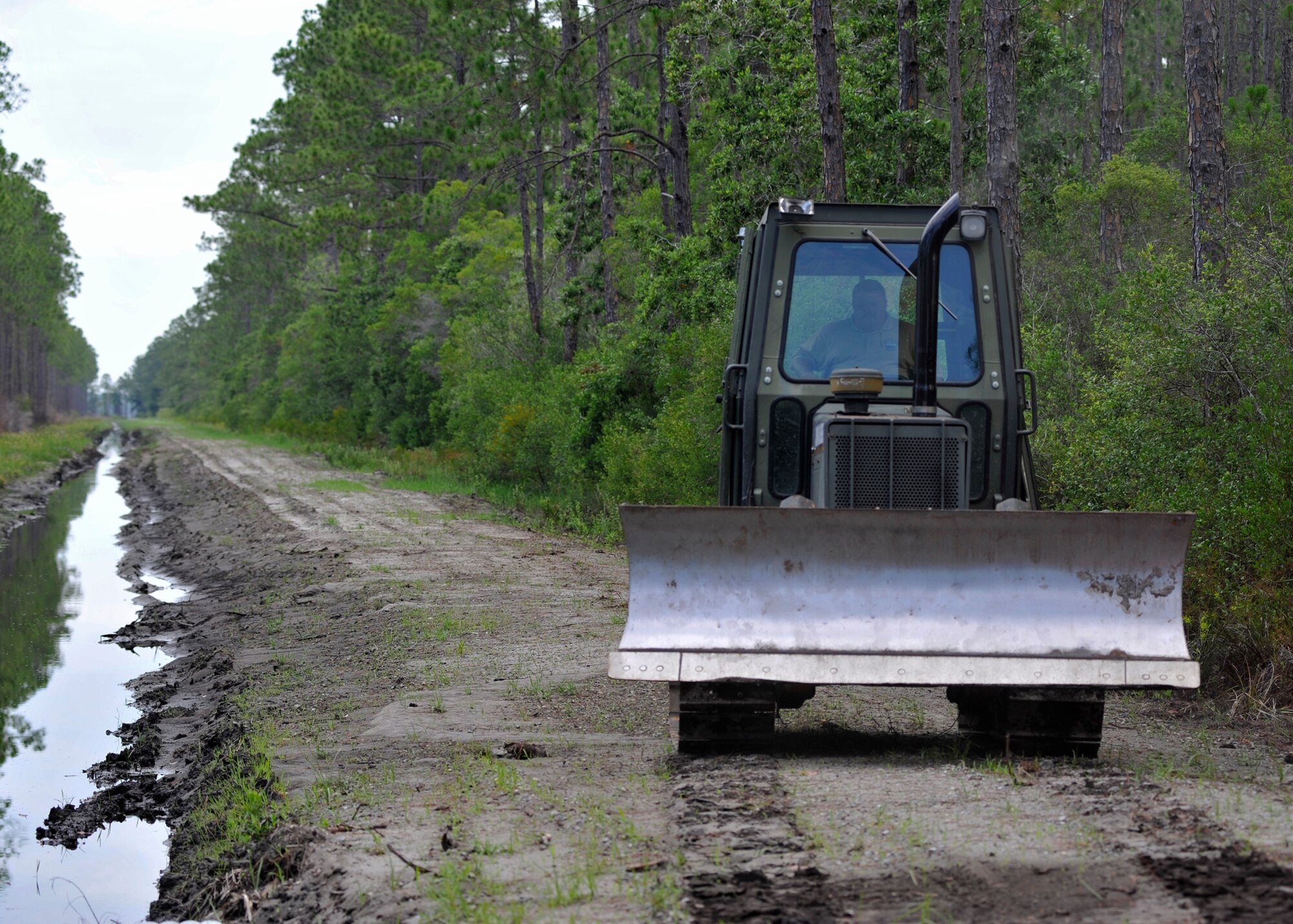Richard Turner, a forest technician assigned to the 325th Civil Engineer Squadron Natural Resources forest management section, drives a tractor in preperation for road reestablishing at Tyndall Air Force Base, Fla., June 14, 2016. Forest management supports the Tyndall mission by providing wildfire protection, forest enhancement and restoration, endangered species and wildlife habitiat improvement and recreational development. (U.S. Air Force photo by Senior Airman Sergio A. Gamboa/Released)
