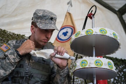 Spc. Thomas Branson, an Army Reserve culinary specialist, 311th Sustainment Command (Expeditionary), decorates an Army birthday cake, Camp Roberts, Calif., June 14, 2016.