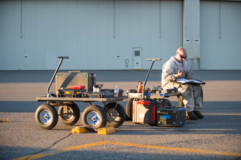 U.S. Air Force Staff Sgt. Theodore Lau, a 354th Aircraft Maintenance Squadron aerospace proposition technician, sits on his tool cart filling out continuity paperwork after the test run of an F-16 Fighting Falcon fighter aircraft while working swing shift June 14, 2016, during RED FLAG-Alaska (RF-A) 16-2 at Eielson Air Force Base, Alaska. RF-A 16-2, the largest exercise of it’s kind in six years, simulates the first 10 combat sorties during the initial stages of war or a surge operation, which pushes pilots to fly jets built in the 80s to their limits, creating a 185 percent usage compared to normal flying operations. (U.S. Air Force photo by Staff Sgt. Shawn Nickel/Released)
