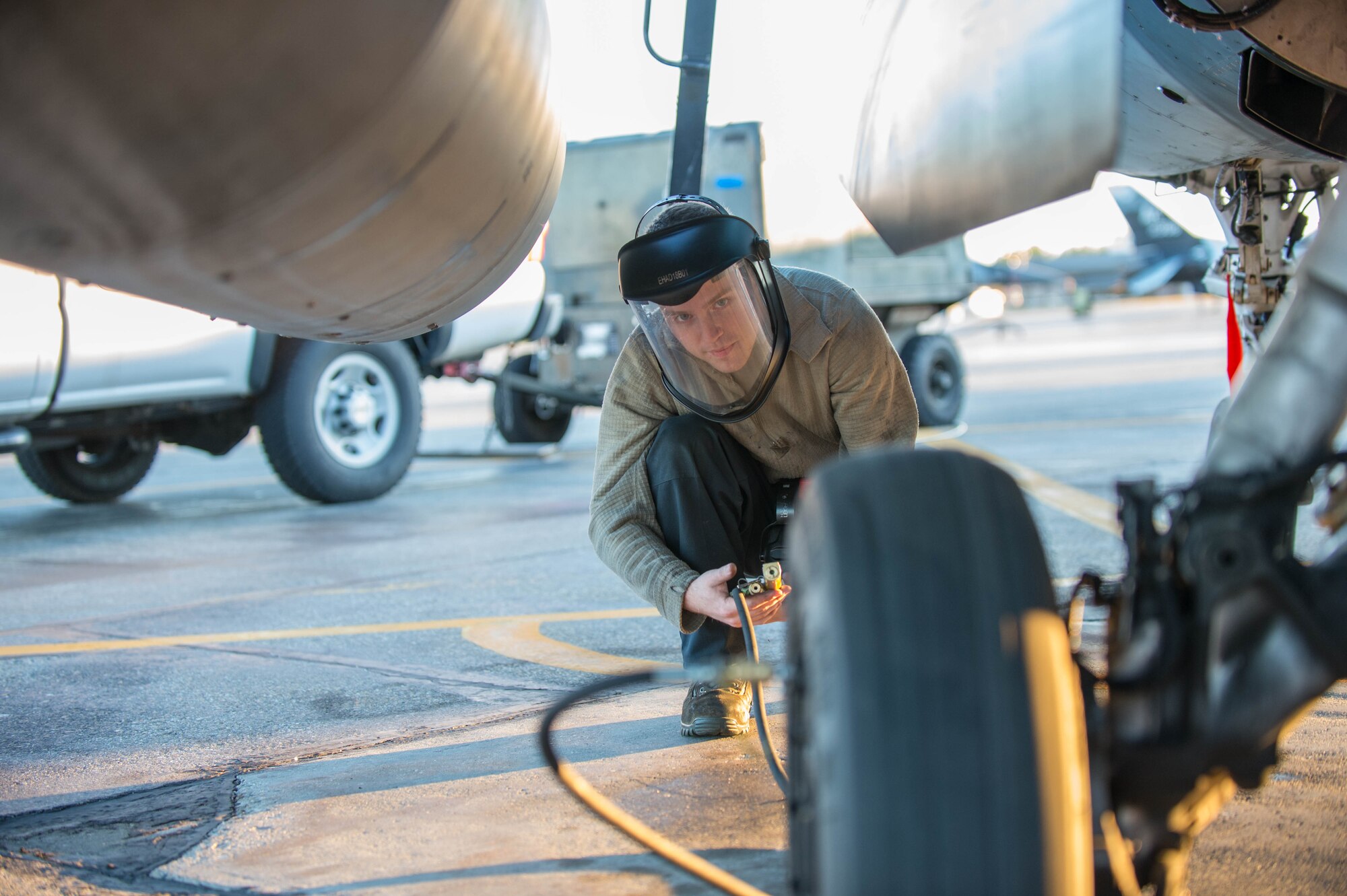 Airman 1st Class Ryan Bateman, a 354th Aircraft Maintenance Squadron assistant dedicated crew chief, tops off the air in the tire of an F-16 Fighting Falcon fighter aircraft while working swing shift June 14, 2016, during RED FLAG-Alaska (RF-A) 16-2 at Eielson Air Force Base, Alaska. RF-A 16-2, the largest exercise of it’s kind in six years, simulates the first 10 combat sorties during the initial stages of war or a surge operation, providing training for support personnel in sustainment of large-force deployed air operations. (U.S. Air Force photo by Staff Sgt. Shawn Nickel/Released)