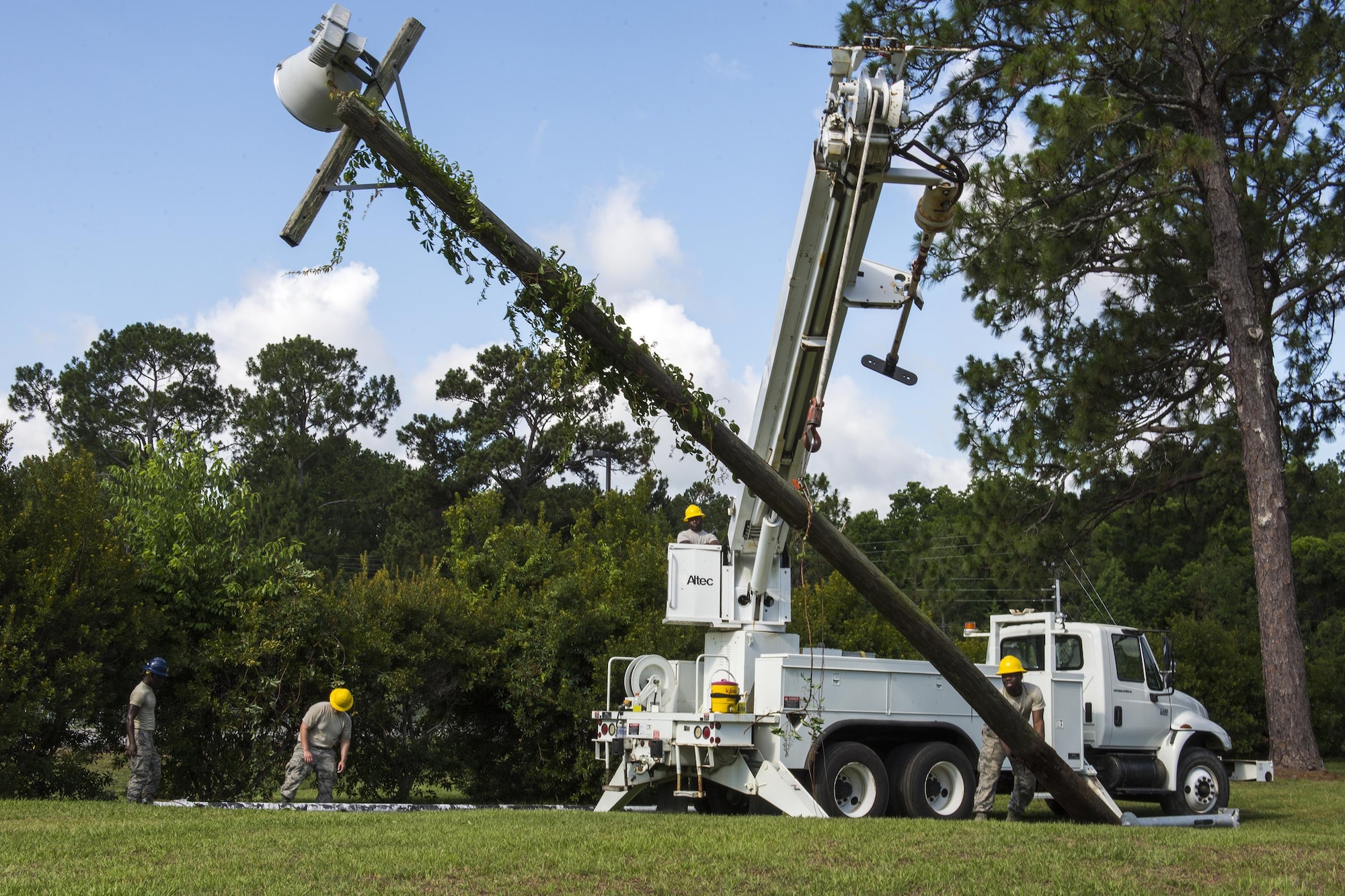 U.S. Air Force Airmen from the 23d Civil Engineer Squadron and 202nd Red Horse Squadron team-up to remove a light fixture, June 15, 2016, at Moody Air Force Base, Ga. The older wooden light fixtures were replaced with newer metal ones hoisting LED lights. (U.S. Air Force photo by Airman Daniel Snider/Released)