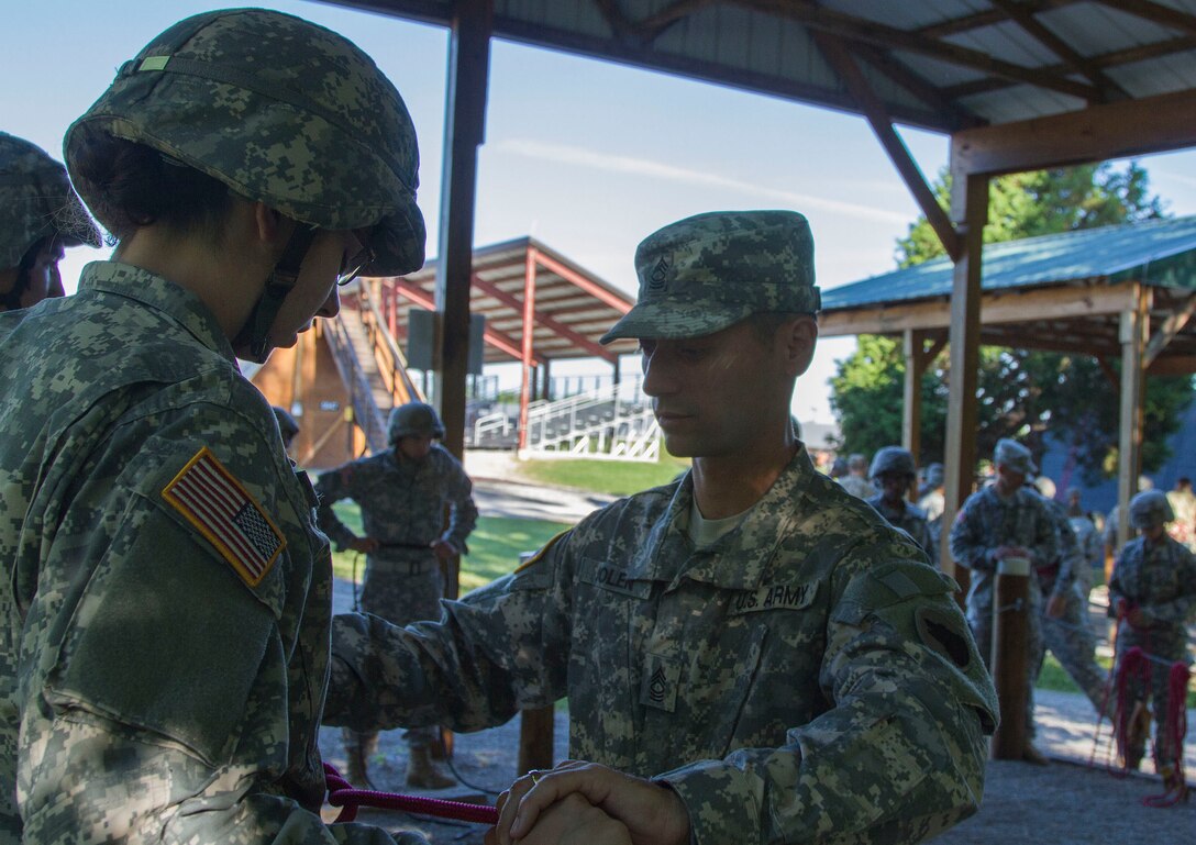 An Army Reserve repel instructor, attached to Task Force Wolf, assists a cadet during leadership course training, at the U.S. Army Cadet Command, Ft. Knox, Ky., June 11. Cadets learn how to tie a Swiss seat knot during repel training. (U.S. Army photo by Sgt. Karen Sampson/ Released.)