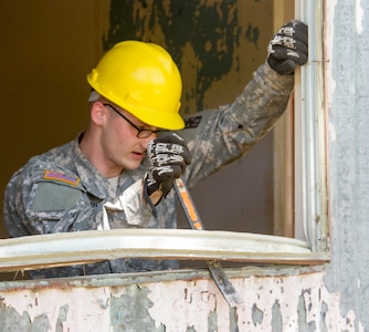 JOINT BASE MCGUIRE-DIX-LAKEHURST, N.J. - Spc. Matthew Robinson, a carpenter of the 358th Engineer Company based in New Cumberland, Pa., removes a window frame during demolition of a latrine during training exercise Castle Installation Related Construction 2016. (U.S. Army photo by Sgt. Anshu Pandeya, 372nd Mobile Public Affairs Detachment)