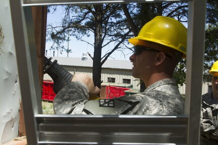 JOINT BASE MCGUIRE-DIX-LAKEHURST, N.J. - Sgt. Brandon Myers, a construction site manager for New Cumberland, Pa.-based 358th Engineer Company, saws through a building frame during demolition of a latrine during training exercise Castle Installation Related Construction 2016. (U.S. Army photo by Sgt. Anshu Pandeya, 372nd Mobile Public Affairs Detachment)