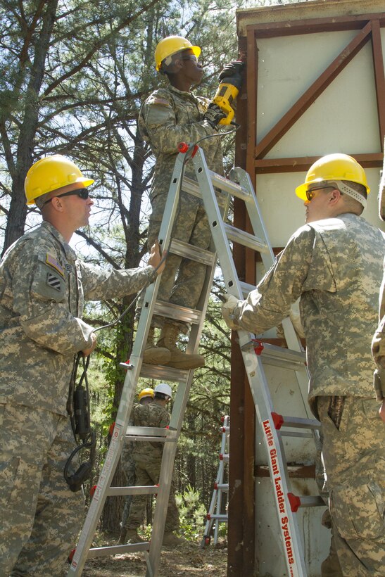 JOINT BASE MCGUIRE-DIX-LAKEHURST, N.J. - Sgt. Brandon Myers, project site supervisor, and Pfc. Nathan Rupert, interior electrician, supervise and hold a ladder as Spc. Pierre Mede, a plumber saws through a building's frame during demolition of a latrine during training exercise Castle Installation Related Construction 2016. The Soldiers are members of the 358th Engineer Company based in New Cumberland, Pa. (U.S. Army photo by Sgt. Anshu Pandeya, 372nd Mobile Public Affairs Detachment)