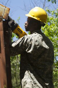 JOINT BASE MCGUIRE-DIX-LAKEHURST, N.J. - Spc. Pierre Mede, a plumber for the New Cumberland, Pa.-based 358th Engineer Company, saws through a building's frame during demolition of a latrine during training exercise Castle Installation Related Construction 2016. (U.S. Army photo by Sgt. Anshu Pandeya, 372nd Mobile Public Affairs Detachment)