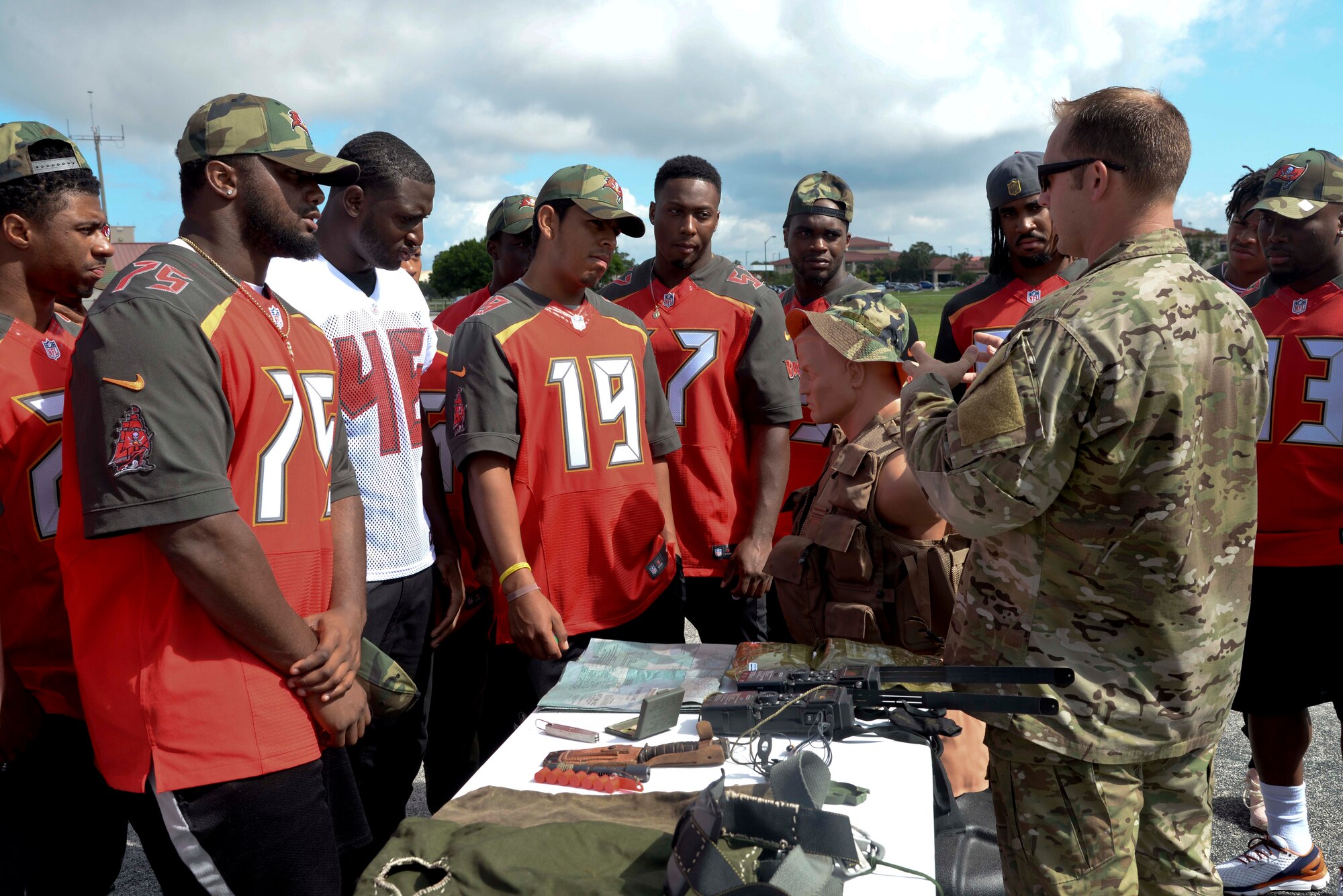 (Right) Staff Sgt. Benjamin Heard, Survival, Evasion, Resistance and Escape specialist, explains the use of survival tools to rookies of the Tampa Bay Buccaneers at MacDill Air Force Base, Fla. June 10, 2016. The rookies received the opportunity to test equipment, learn basic survival skills and sample food rations. 