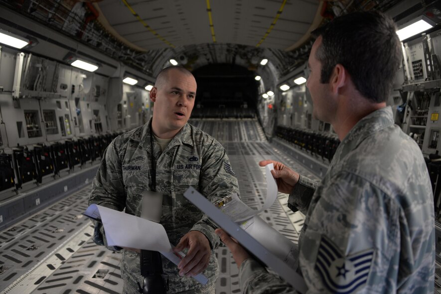 Tech. Sgt. Damon Thurman, 860th Aircraft Maintenance Squadron flight line expediter, discusses the C-17 inspection process with Tech. Sgt. Blake Thornton, 860th AMXS flight line expediter, during an inspection of a Globemaster III at Travis Air Force Base, Calif. The 860th AMXS is responsible for maintaining more than a dozen C-17's valued at $2.9 billion. Photo altered for security reasons. (U.S. Air Force photo by Tech. Sgt. James Hodgman)
