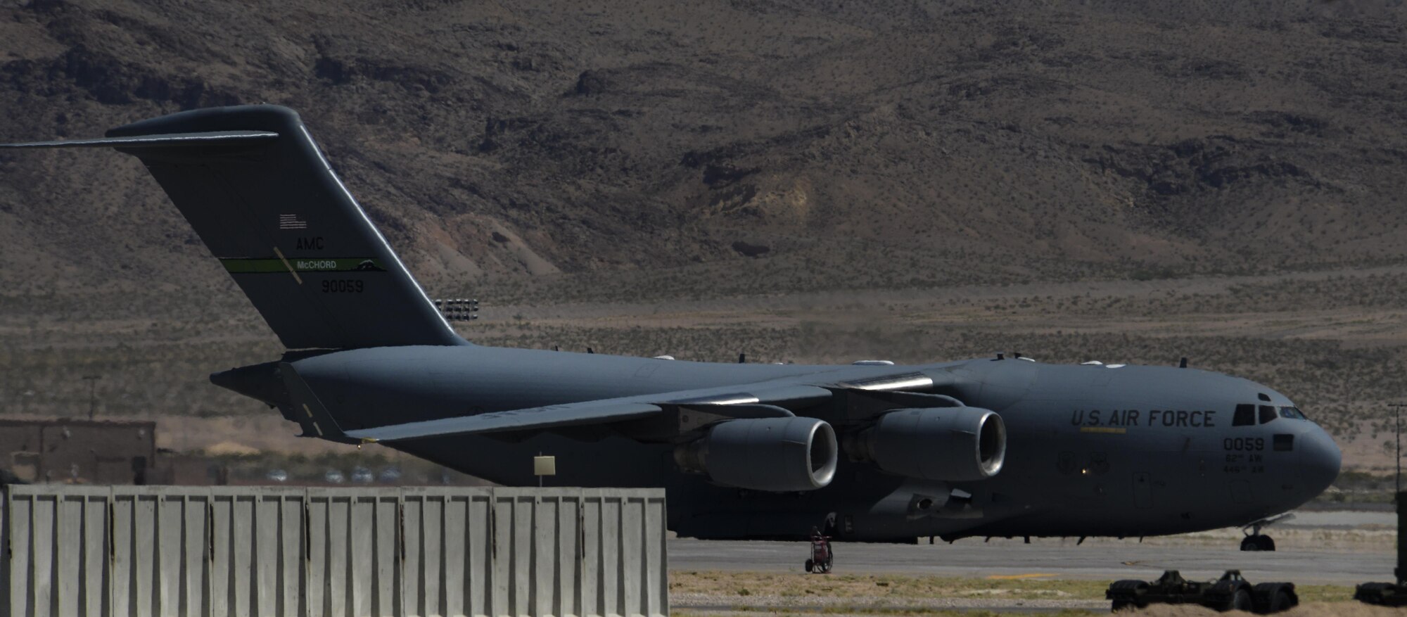 A C-17 carrying Airmen from the 66th Rescue Squadron and 823rd Maintenance Squadron returning home from deployment taxis down the runway at Nellis Air Force Base, Nev., June 7. The Airmen were bused from the Nellis AFB flightline to the 823rd MXS hangar where their families awaited their arrival. (U.S. Air Force photo by Airman 1st Class Kevin Tanenbaum)