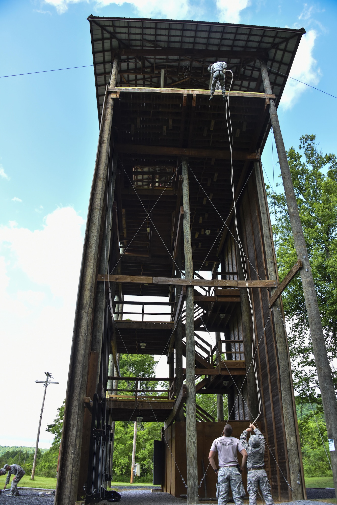 A 911th Security Forces Squadron member rappels from a five-story tower as an Army combat engineer, 119th Engineer Company (Sapper), West Virginia Army National Guard out of Moundsville, West Virginia, looks on at Camp Dawson, West Virginia, June 8, 2016. The Army combat engineers provided rappelling training and oversight during the 911th SFS’s annual tour training at the West Virginia Army National Guard installation. (U.S. Air Force photo by Staff. Sgt. Jonathan Hehnly)