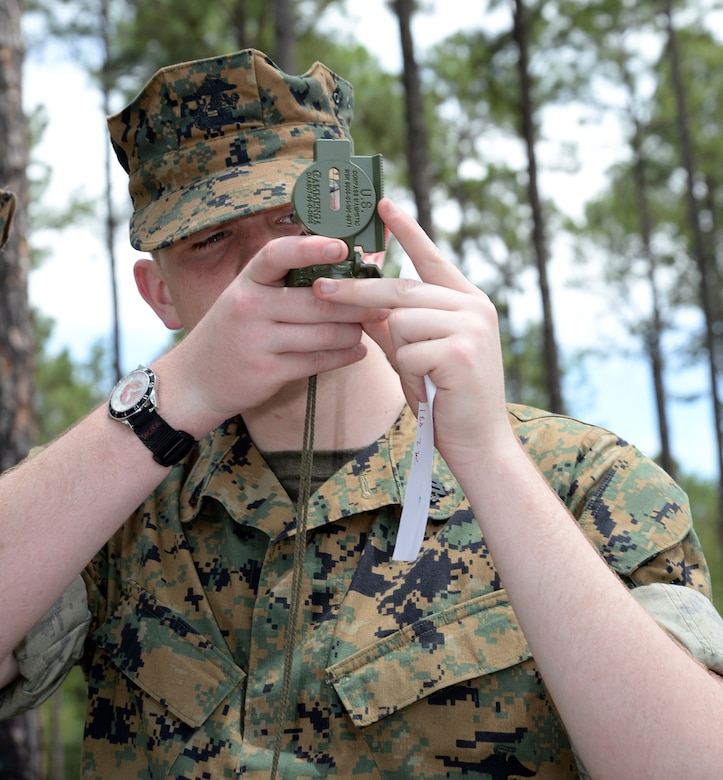 A Marine Corps Junior Reserve Officers Training Corps cadet from Plaquemine High School, Plaquemine, La., puts his compass and map reading skills to test while navigating the Land Navigation Course during a Cadet Leadership Camp aboard Marine Corps Logistics Base Albany, June 8.