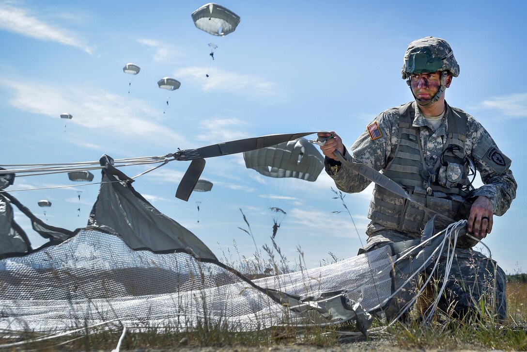 Army Sgt. John Arriaga recovers his parachute after participating in an airborne proficiency operation during Exercise Arctic Aurora at Joint Base Elmendorf-Richardson, Alaska, June 9, 2016. Arriaga is assigned to the 25th Infantry Division's Company B, 3rd Battalion, 509th Parachute Infantry Regiment, 4th Infantry Brigade Combat Team (Airborne). Air Force photo by Justin Connaher