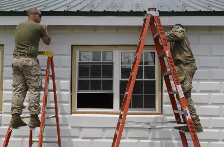 Lance Cpl. Michael J. Ligue (left), a combat engineer with Company C, 6th Engineer Support Battalion, 4th Marine Logistics Group, Marine Forces Reserve, and Pvt. Antonio Comparetto (right), a sapper with 131 Commando Squadron Royal Engineers, British army, place aluminum fascia trim on a barracks renovation project during exercise Red Dagger at Fort Indiantown Gap, Penn., June 11, 2016. As part of the exercise, the Marines and British commandos worked on various renovation and construction projects around the Army base. Exercise Red Dagger is a bilateral training exercise that gives Marines an opportunity to exchange tactics, techniques and procedures as well as build working relationships with their British counterparts. (U.S. Marine Corps photo by Sgt. Ian Leones/Released)