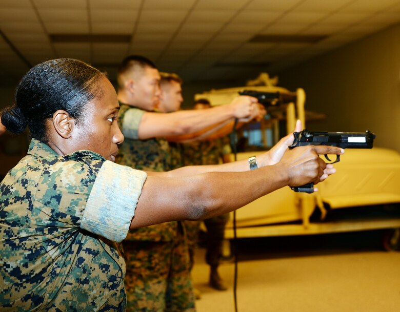 Marines use Marine Corps Logistics Base Albany’s Indoor Simulated Marksmanship Trainer to help familiarize themselves with weapons before qualifying on the pistol range, recently.