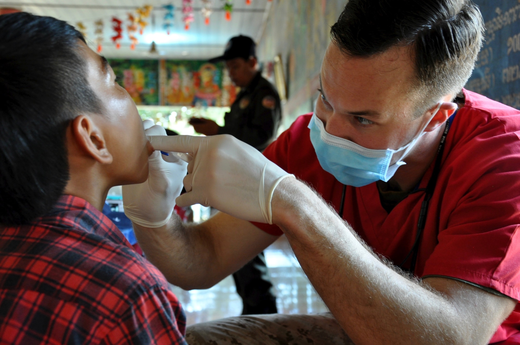 U.S. Navy Lieutenant Matthew Kanter examines a young Cambodian boy during a dental hygiene outreach event for Angchhum Trapeang Chhouk School in Kampot Province, Cambodia, June 15, 2016. Approximately 187 children from the school received oral hygiene education and fluoride treatments along with a toothbrush and toothpaste to take home as part of Pacific Angel 16-2. Pacific Angel includes general health, dental, optometry, pediatrics, physical therapy and engineering programs as well as various humanitarian aid and disaster relief subject matter expert exchanges. The mission enhances participating nations’ humanitarian assistance and disaster relief capabilities while providing needed services to people throughout the region. Kanter is a U.S. Navy dentist deployed from Marine Corps Air Station Miramar. (U.S. Air Force photo by Capt. Susan Harrington/Released)