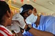 Phon Pagna, a dental administrator for East Meets West non-governmental organization examines a young Cambodian girl from Angchhum Trapeang Chhouk School in Kampot Province, Cambodia, June 15, 2016, as part of a dental hygiene outreach event during Pacific Angel 16-2. Approximately 187 children from the school attended the event and received oral hygiene education and fluoride treatments. The oral hygiene education day was planned by East Meets West NGO in partnership with the Kampot Provincial Health Clinic, but executed by both U.S., Australian and Cambodian dentists and volunteers, further building on the relationships formed throughout the Pacific Angel 16-2 mission. (U.S. Air Force photo by Capt. Susan Harrington/Released)