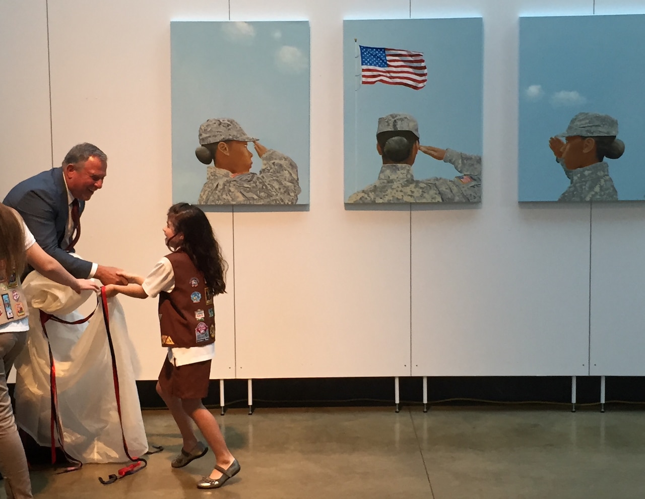 Artist Steve Alpert thanks a Brownie Scout for helping him unveil the triptych “Portrait of a Woman” at the Women in Military Service for America Memorial located at the entrance of Arlington National Cemetery, Va., June 13, 2016. DoD photo by Jim Garamone