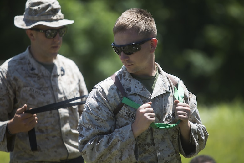 Petty Officer 3rd Class Benjamin Rawson (left), a Fleet Marine Force hospital corpsman with Company C, 6th Engineer Support Battalion, 4th Marine Logistics Group, Marine Forces Reserve, demonstrates the use of a combat rescue sling with assistance from Cpl. Timothy E. Skronski (right), a team leader with Company C, during exercise Red Dagger at Fort Indiantown Gap, Penn., June 13, 2016. Red Dagger is a bilateral training exercise that gives Marines an opportunity to exchange tactics, techniques and procedures as well as build working relationships with their British counterparts.  (U.S. Marine Corps photo by Sgt. Ian Leones/Released)