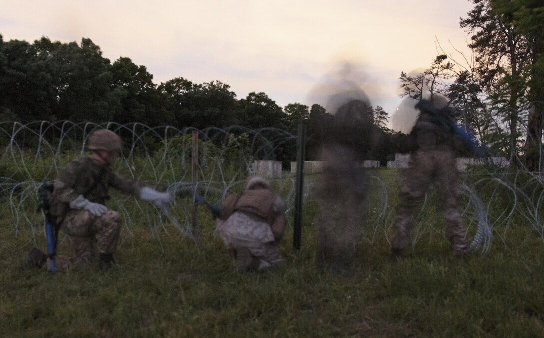 A team of combat engineers with Company C, 6th Engineer Support Battalion, 4th Marine Logistics Group, Marine Forces Reserve, and commandos with 131 Commando Squadron Royal Engineers, British army, breach a defensive obstacle during a simulated raid on an urban compound during exercise Red Dagger at Fort Indiantown Gap, Penn., June 13, 2016. Combat engineers enhance a force’s momentum by physically shaping the battle space to enhance a unit’s use of space and time while denying the enemy unencumbered movement. Red Dagger is a bilateral training exercise that gives Marines an opportunity to exchange tactics, techniques and procedures as well as build working relationships with their British counterparts. (U.S. Marine Corps photo by Sgt. Ian Leones/Released)