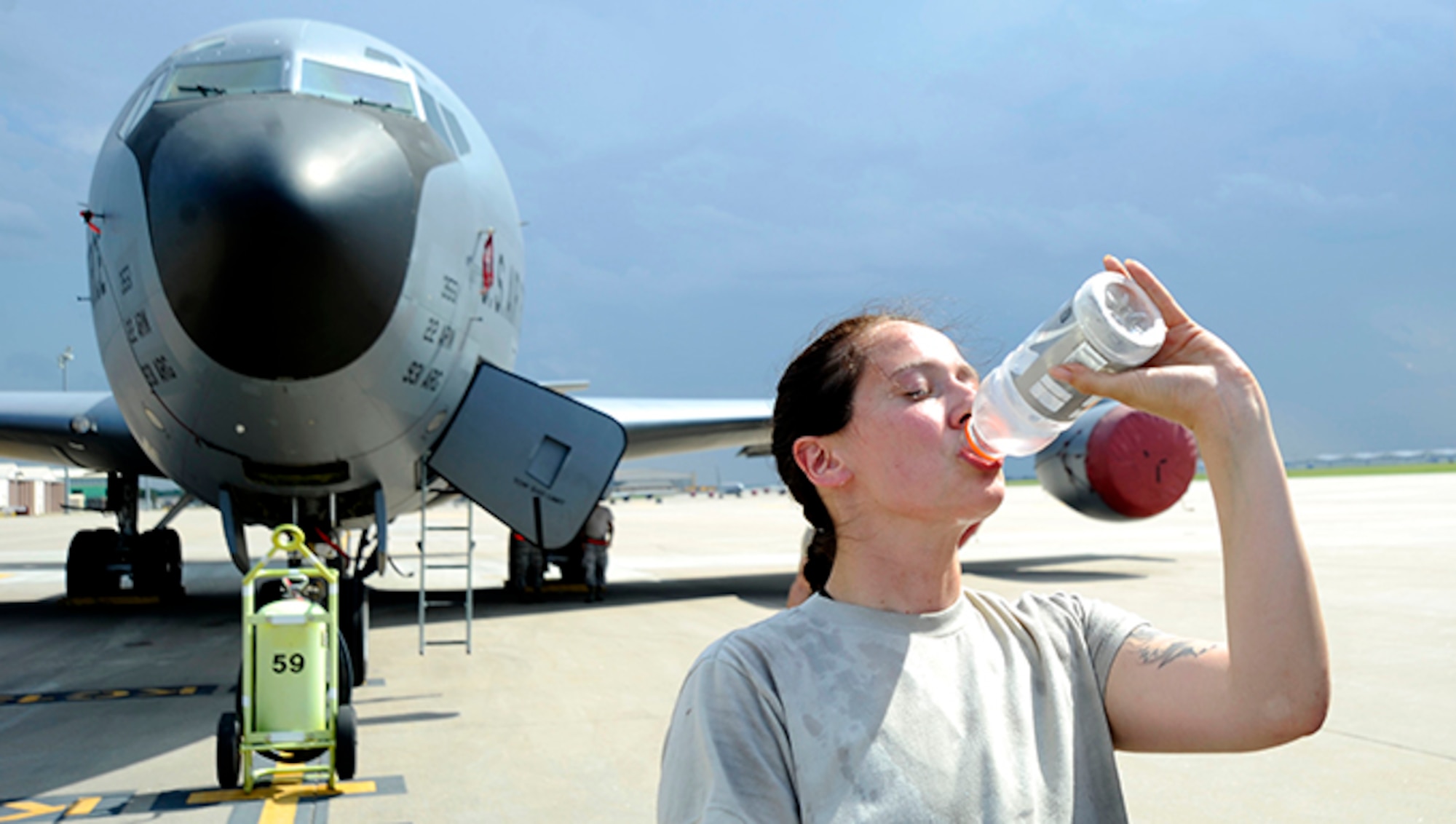 Senior Airmen Johanna Magner, 22nd Aircraft Maintenance Squadron crew chief, drinks water on the flightline in front of a KC-135 Stratotanker, June 15, 2016, at McConnell Air Force Base, Kan. With rising temperatures during the summer months, Airmen are encouraged to drink more water than normal to stay hydrated. (U.S. Air Force photo/Airman 1st Class Jenna K. Caldwell)