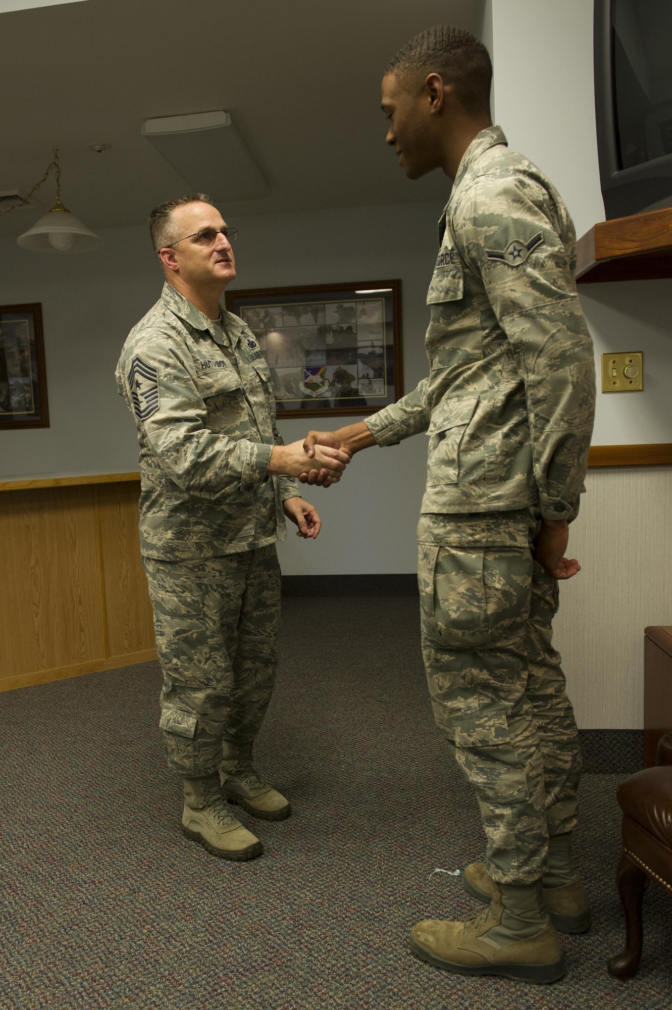 U.S. Air Force Chief Master Sgt. Harold Hutchison, the Pacific Air Forces command chief, coins Airman Donovan Stewart, a 354th Logistics Readiness Squadron vehicle operator, June 15, 2016, at Eielson Air Force Base, Alaska. Stewart was recognized for his professionalism and dedication to transporting Hutchison and other guests while they visited Eielson during RED FLAG-Alaska 16-2. (U.S. Air Force photo by Airman Isaac Johnson/Released)