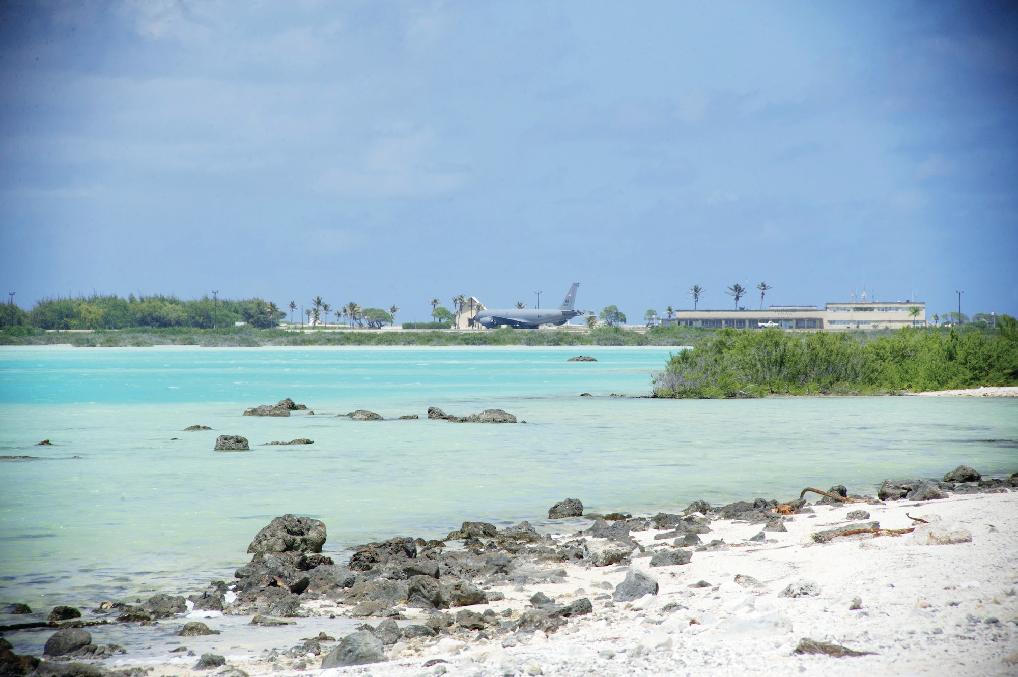 An Air Force KC-135 Stratotanker from the 168th Air Refueling Wing at Eielson Air Force Base rests on the tarmac across the wishbone-shaped lagoon at Wake Island Airfield in the mid-Pacific. The tanker ferried 32 personnel to and from Joint Base Elmendorf-Richardson in Anchorage for a biannual inspection of the island’s contractors, facilities, historic landmarks and wildlife preserves. (U.S. Air Force photo/1st Lt. Michael Trent Harrington)
