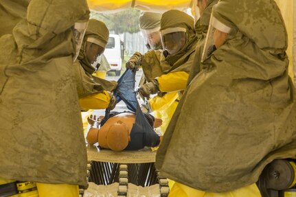 U.S. Navy Sailors from the Robert M. Casey Medical and Dental Clinic remove clothing from a simulated victim during first-receiver operations training at Marine Corps Air Station Iwakuni, Japan, June 9, 2016. Provided by the Decontamination, Education and Consulting on Nuclear, Biological and Chemical Limited Liability Company, the course educates first receivers in conducting decontamination, field treatment and saving victims from chemical, biological, radiological and nuclear threats.  Conducting this training helps refresh Sailors on their tactical skills sets specific to CBRN response, maintain situational readiness and ensures the safety of personnel. (U.S. Marine Corps photo by Lance Cpl. Aaron Henson/Released)