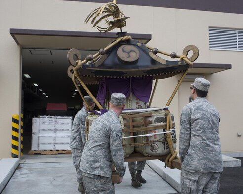 Airmen with the 374th Maintenance Squadron aerospace ground equipment flight download a mikoshi at Yokota Air Base, Japan, Aug. 11, 2015. The Fussa-Yokota Goodwill Exchange Club donated the mikoshi to Yokota Air Base. (U.S. Air Force photo by Yasuo Osakabe/Released)