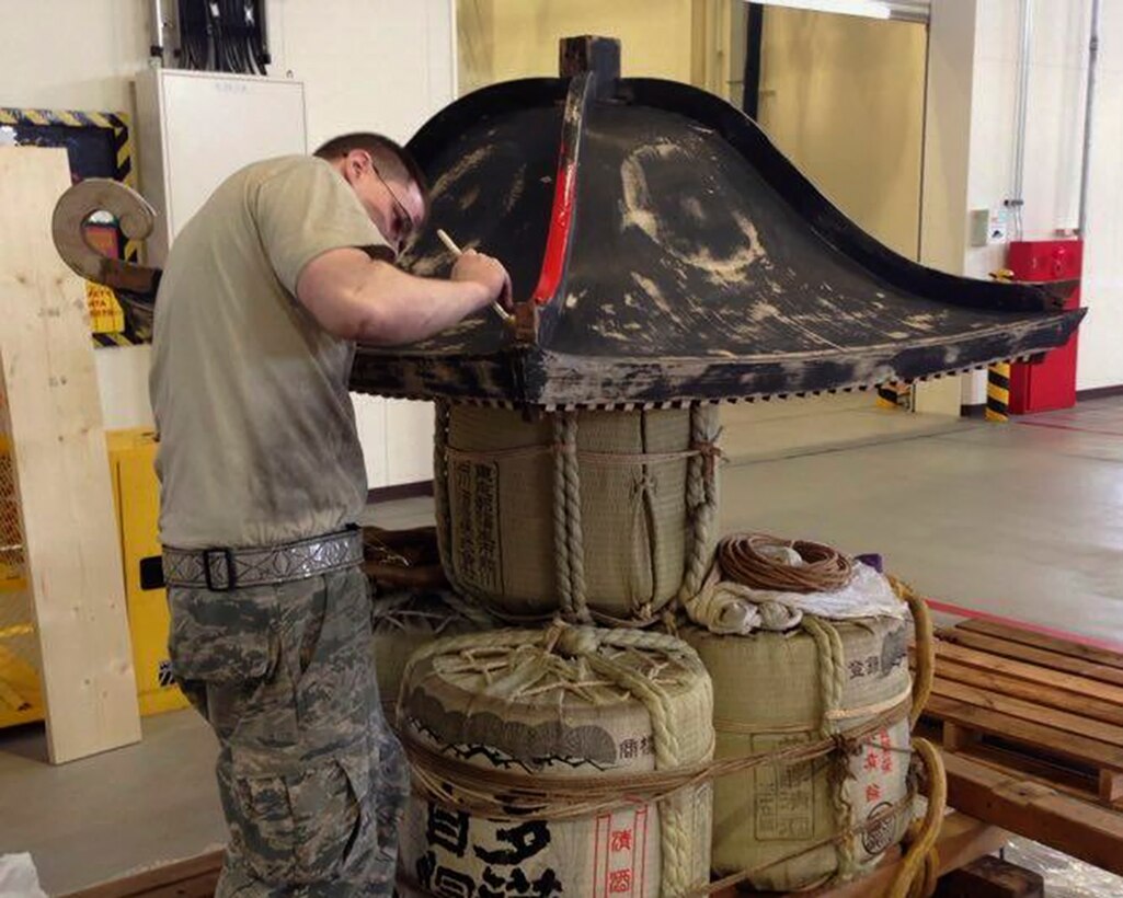 Senior Airman Matthew Platz, 374th Maintenance Squadron aerospace ground equipment journeyman, paints the Wing’s mikoshi at Yokota Air Base, Japan, Feb. 24, 2016. Airmen with the 374th MXS and 374th Maintenance Group worked over 150 hours to sand, strip, paint, and treat the wooden surfaces as well as trimming, shaping, and fitting over 10 square meters of brass to replace the ornate work over the course of one month. (Courtesy photo by 374th Maintenance Squadron AGE flight)