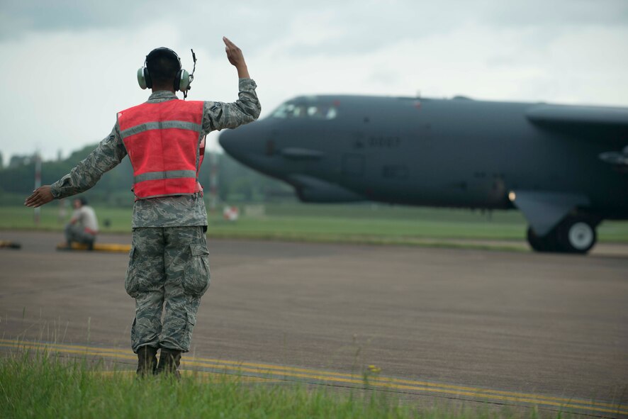 Airman 1st Class Aaron Sampayan, 5th Expeditionary Aircraft Maintenance Squadron assistant dedicated crew chief, guides a B-52H Stratofortress to its parking spot at RAF Fairford, United Kingdom, June 13, 2016. The B-52 flew its first mission in support of exercise Saber Strike 16, which rapidly deploys personnel across the Baltic region, ensuring allied and partner nations are able to quickly assemble and train anywhere they are called to do so. (U.S. Air Force photo/Senior Airman Sahara L. Fales)