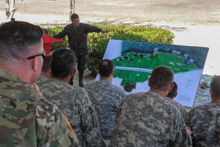 A member of the Honduran military discusses the plan for troop and equipment movement during a Rehearsal of Concept drill in preparation for combined Honduran and U.S. Counter-Transnational Organized Crime operations, in Santa Barbara, Honduras, June 1, 2016. This was the first time the Honduran military hosted and led a RoC drill for a CARAVANA mission, demonstrating an increase in effectiveness due to an expansion of Honduran assets and capabilities. During the RoC drill, one Honduran official highlighted recent data showing a marked decrease of Transnational Criminal Organization freedom of maneuver in northeastern Honduras, attributing it to the continued presence of Honduran security and interdiction teams enabled by Operation CARAVANA. CARAVANA is the name given to the recurring operation whereby Joint Task Force-Bravo provides the Honduran military with airlift support to give Honduran troops freedom of movement and access to outposts in the Gracias a Dios, Colón and Olancho departments to disrupt and deter illicit trafficking of drugs, weapons and money. (U.S. Air Force photo illustration by Capt. David Liapis)