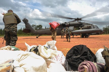 Honduran military members download supplies from a UH-60 Black Hawk helicopter during the twentieth iteration of Operation CARAVANA, in Mocorón, Honduras, June 8, 2016. Joint Task Force-Bravo’s 1st Battalion, 228th Aviation Regiment provided two Black Hawks and two CH-47 Chinooks for the troop transport, in addition to Honduran Air Force UH-1 Hueys. In the past, the Honduran military relied primarily on logistic ships to transport the personnel and supplies, making multiple stops throughout the coastal region before dropping off the troops and returning to home port. The whole process took more than a week, whereas transporting by helicopter takes only a few hours and allows access to even more remote areas. (U.S. Air Force photo by Staff Sgt. Siuta B. Ika)