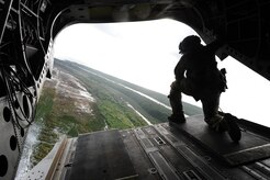 U.S. Army Sgt. King David, 1st Battalion, 228th Aviation Regiment crew chief, looks out the back of a CH-47 Chinook before landing in the Gracias a Dios department of Honduras during the twentieth iteration of Operation CARAVANA, June 9, 2016. CARAVANA is the name given to the recurring operation whereby Joint Task Force-Bravo provides the Honduran military with airlift support to give Honduran troops freedom of movement and access to outposts in the Gracias a Dios, Colón and Olancho departments to disrupt and deter illicit trafficking of drugs, weapons and money. (U.S. Air Force photo by Staff Sgt. Siuta B. Ika)