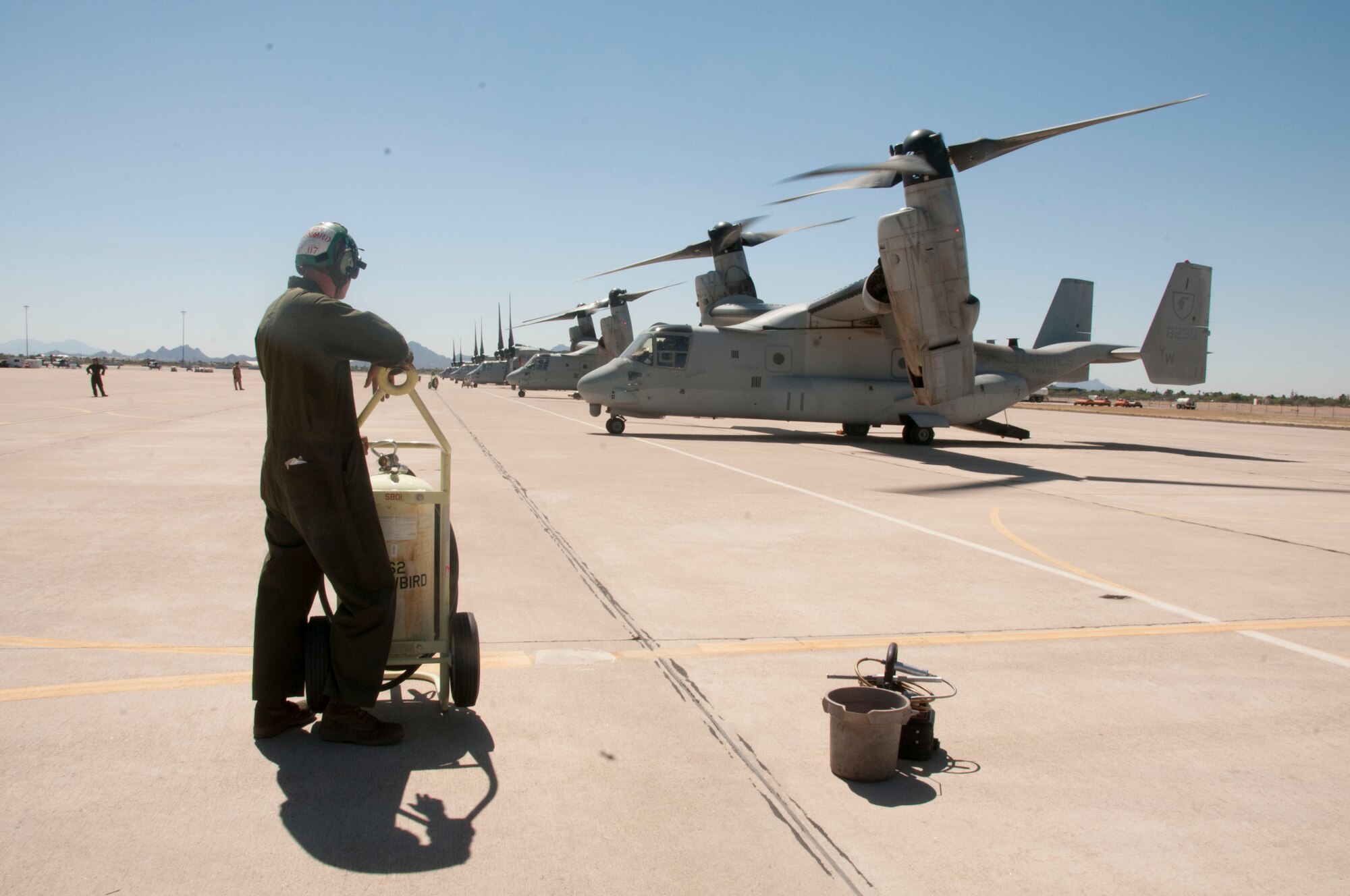 “White Knights” on the north ramp. A Marine Corps crew chief stands by as a fleet of MV-22 Ospreys prepare to take off on May 20 near the 162nd Wing’s Total Force Training Center, located at Davis-Monthan Air Force Base. The versatile joint-service aircraft belongs to the Marine Medium Tiltrotor Squadron - 165, based out of Miramar, California. “Coming here is excellent for training. The environment that we work in right now in theater, with the topography and climate, really mirrors what is here in Arizona,” said Marine Corps Maj. Paul Bisulca, the squadron’s executive officer. (U.S. Air National Guard photo by Tech. Sgt. Erich B. Smith)