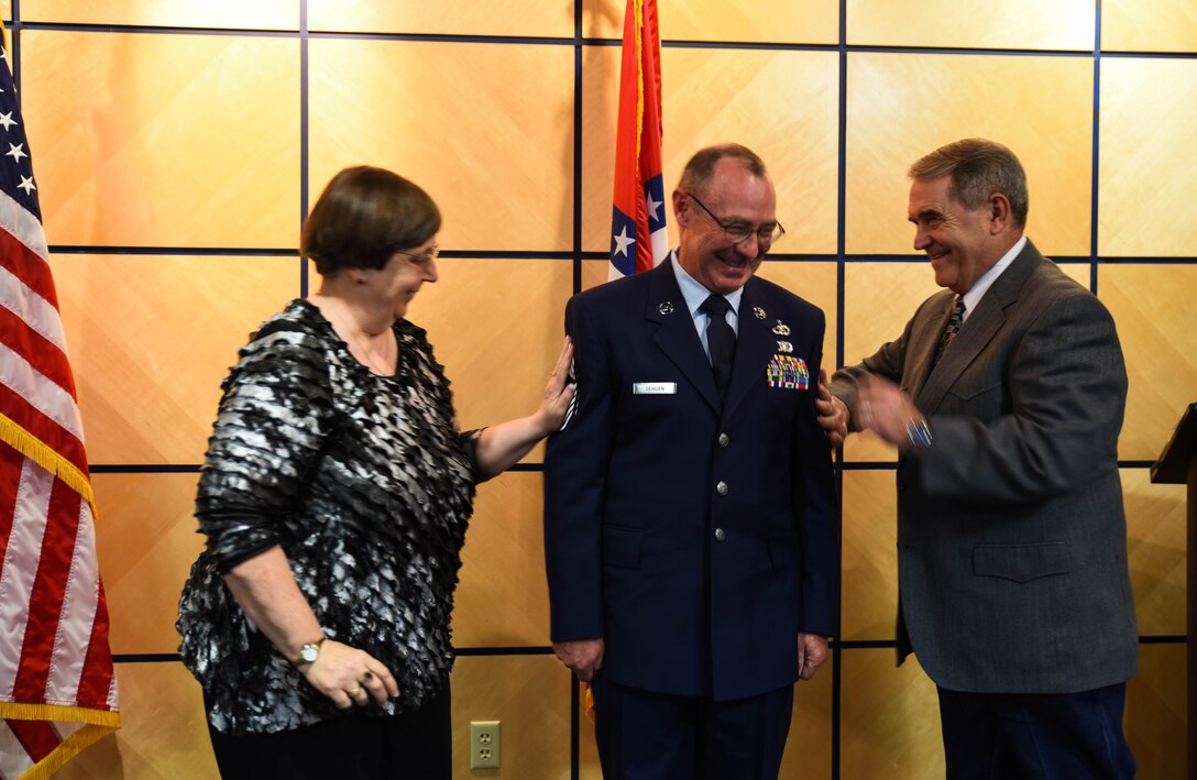 Chief Master Sgt. Ricky Sehorn, chief of transportation, has new rank tacked on June 4, 2016, by Peggy Sehorn and David Hill during his promotion ceremony at Ebbing Air National Guard Base, Fort Smith, Ark. Sehorn has served in vehicle maintenance for the past 24 years and has been chief of transportation since 2014. (U.S. Air National Guard photo by Senior Airman Cody Martin/Released)