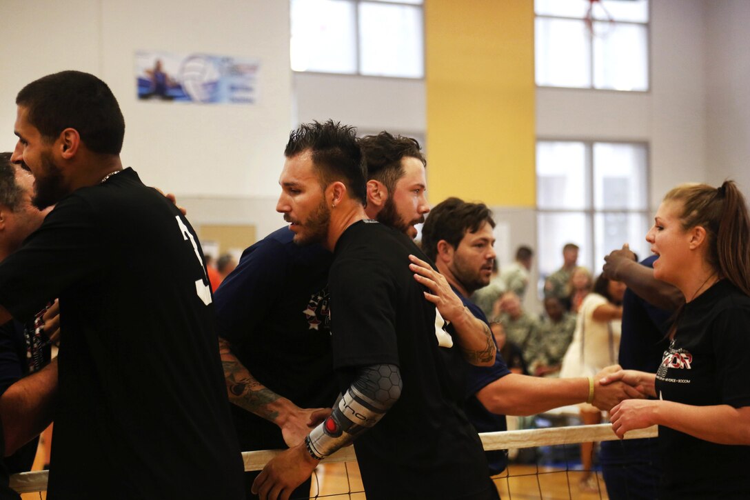 Team Army athletes, foreground, shake hands with competitors after a sitting volleyball match during the 2016 Department of Defense Warrior Games at the U.S. Military Academy in West Point, N.Y., June 15, 2016. Army photo by Pfc. Stefan English