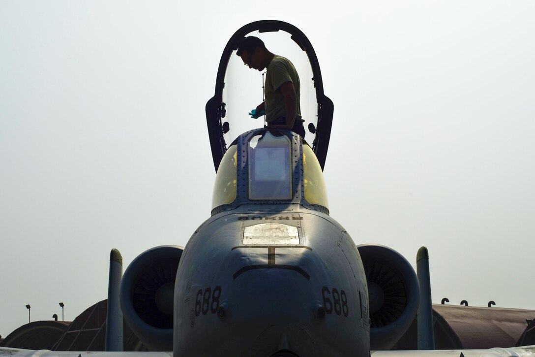 Air Force Senior Airman Paul Willett cleans the inside of the canopy on an A-10 Thunderbolt II at Osan Air Base, South Korea, June 9, 2016. Air Force photo by Senior Airman Victor J. Caputo